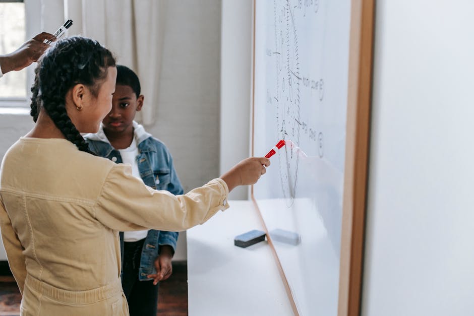 Children engaging in a hands-on learning activity at a whiteboard in a modern classroom setting