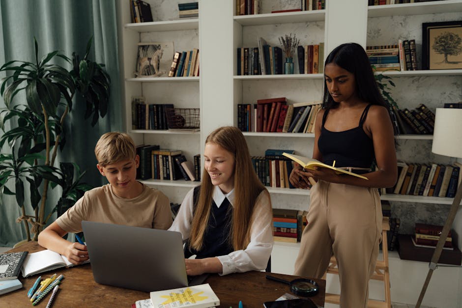 Teen students engaged in a study session with a laptop and books in a library setting, emphasizing teamwork and education.
