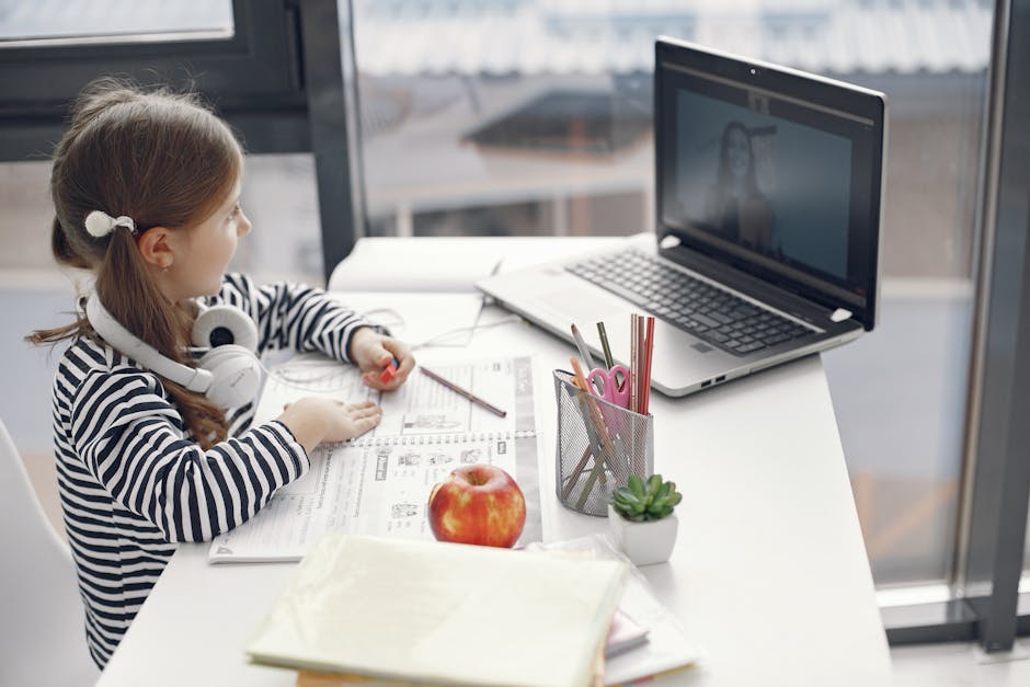 Girl studying online at home on a laptop with educational materials